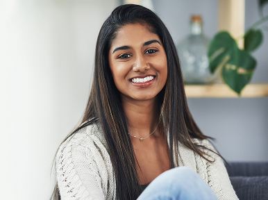Woman smiling at home, representing healthy, confident smile and results from general or cosmetic dentistry